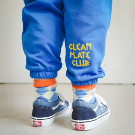 Close-up of chain embroidery on kids blue sweatpants, featuring Clean Plate Club text detail.