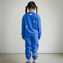 Full outfit back view of kids blue Clean Plate Club sweatshirt styled with matching embroidered sweatpants from Brrr. The sweatshirt features playful food-themed chain embroidery, including a plate motif on the front and fork and knife design on the back, combining comfort, style, and durability for everyday wear.