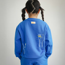 Back view of Brrr Clean Plate Club kids sweatshirt in blue, featuring chain-stitched embroidery of a fork and knife motif along the back for a fun food-inspired design. Includes medium-weight cotton blend fabric and relaxed fit, perfect for cool weather kidswear.