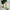 Kids Brrr Face color block socks in yellow, orange, green, and burgundy knit sections, featuring the Brrr face logo on the orange ankle, styled with green corduroy overalls