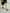 Kids Brrr Face color block socks in yellow, orange, green, and burgundy knit sections, featuring the Brrr face logo on the orange ankle, styled with green corduroy overalls