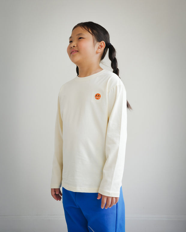 Side view of children’s ivory long sleeve shirt featuring embroidered Brrr logo detail