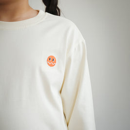 Close-up of embroidered Brrr logo on kids ivory cotton t-shirt